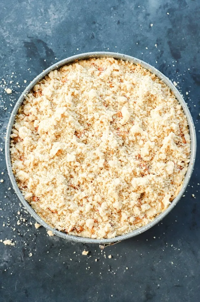 caramel apple crumble cheesecake before baking in pan