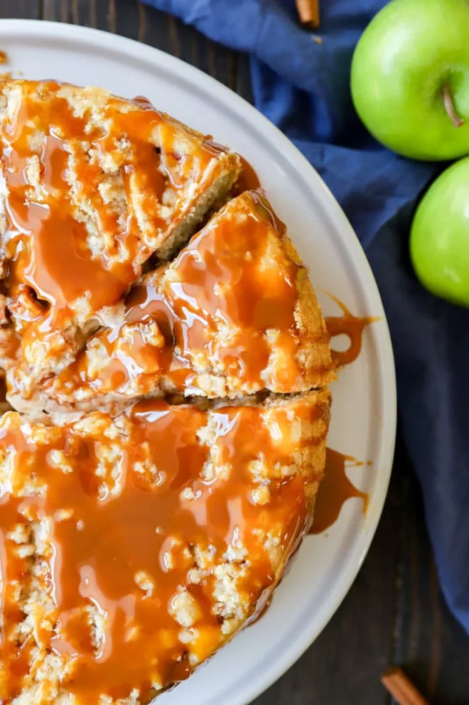 caramel apple crumble cheesecake cut into pieces on cake stand