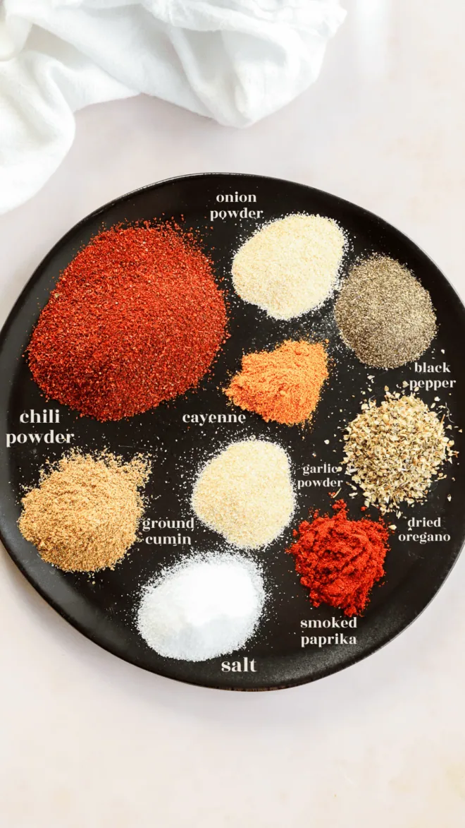 ingredients for homemade chili seasoning recipe on plate with text labels