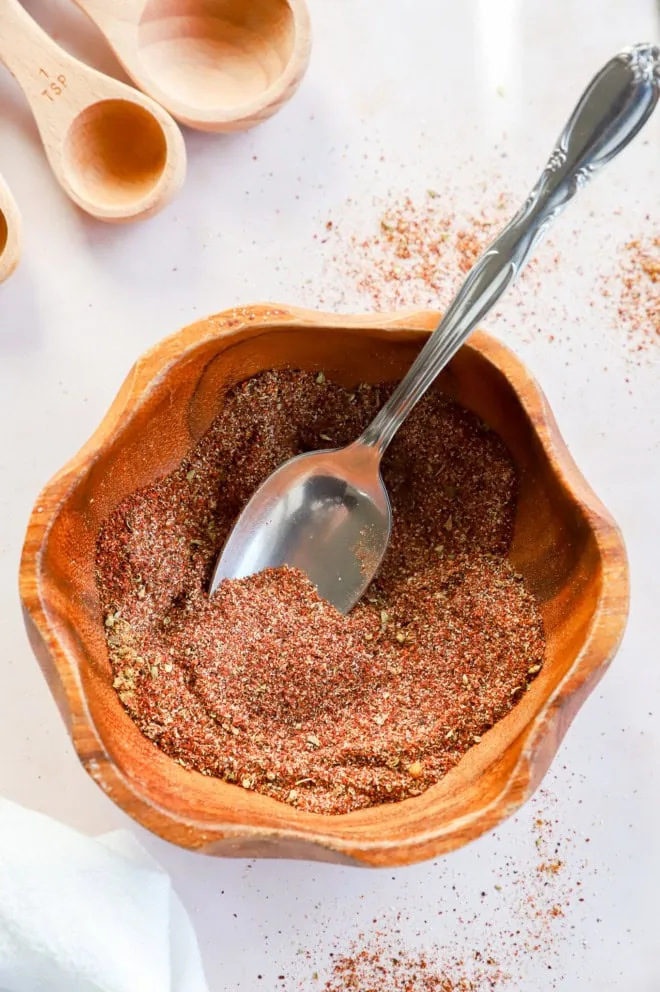 Spoon and bowl of homemade spice mixture for soups