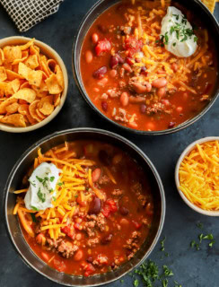 bowls of homemade beef stew with cheese sour cream on top