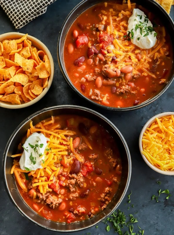 bowls of homemade beef stew with cheese sour cream on top