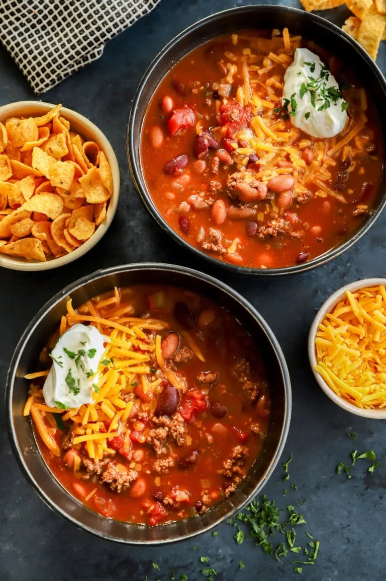 bowls of homemade beef stew with cheese sour cream on top