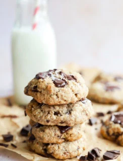 stack of oatmeal chocolate chunk cookies with a carafe of milk