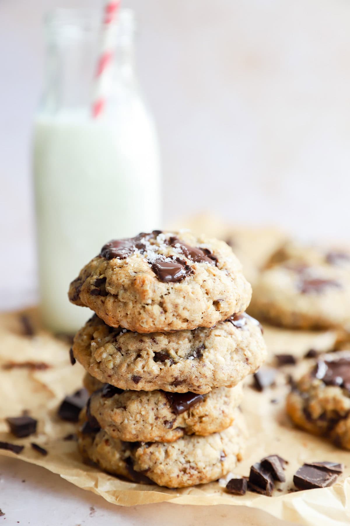 stack of oatmeal chocolate chunk cookies with a carafe of milk