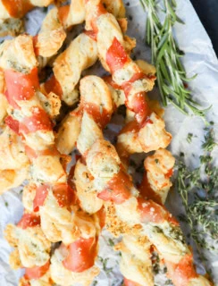 easy puff pastry italian appetizer on parchment paper with fresh herbs