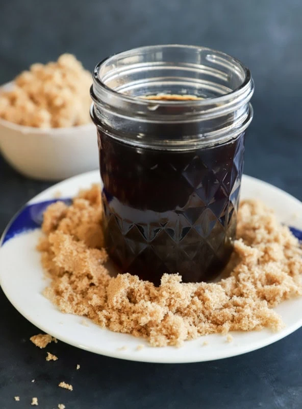 mason jar of brown sugar simple syrup with brown sugar on the plate