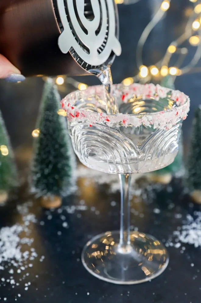 pouring a peppermint martini into a coupe glass