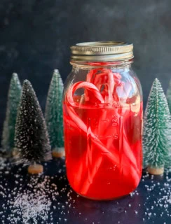 peppermint vodka with candy canes in a mason jar with christmas trees