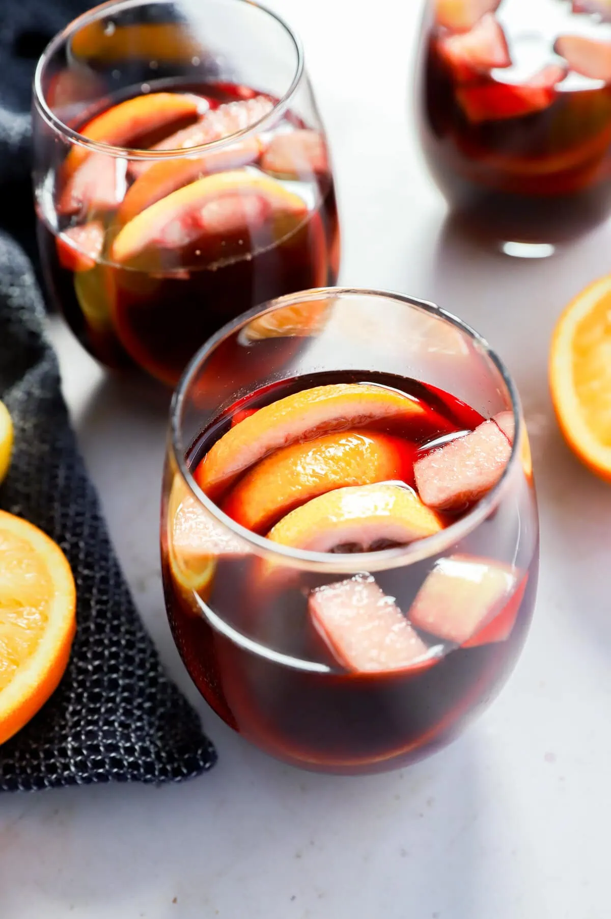 glasses of fruity punch with orange halves and a napkin