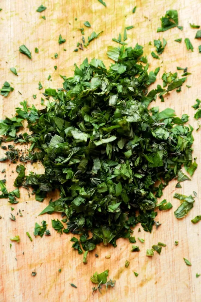 freshly chopped herbs on cutting board