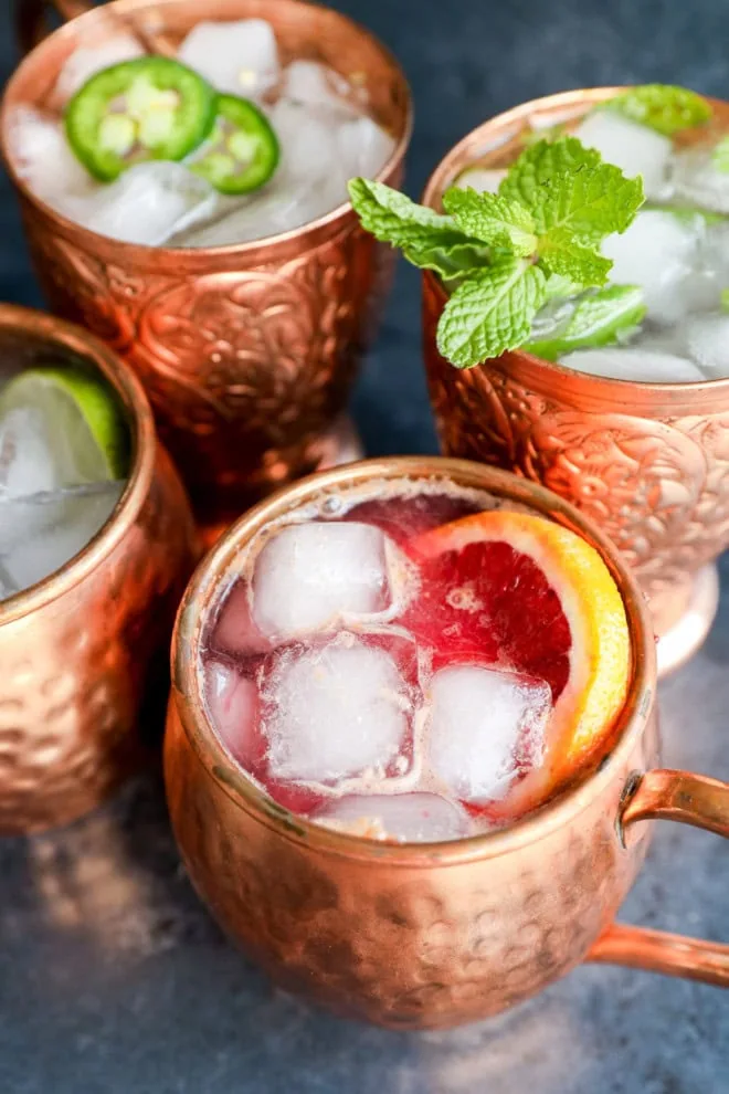 variations of non-alcoholic drinks with fresh herbs and fruits in copper mugs