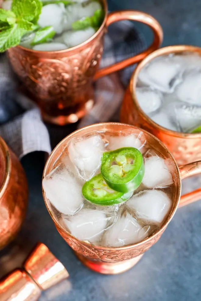 spicy non-alcoholic drink in copper mug with copper jigger