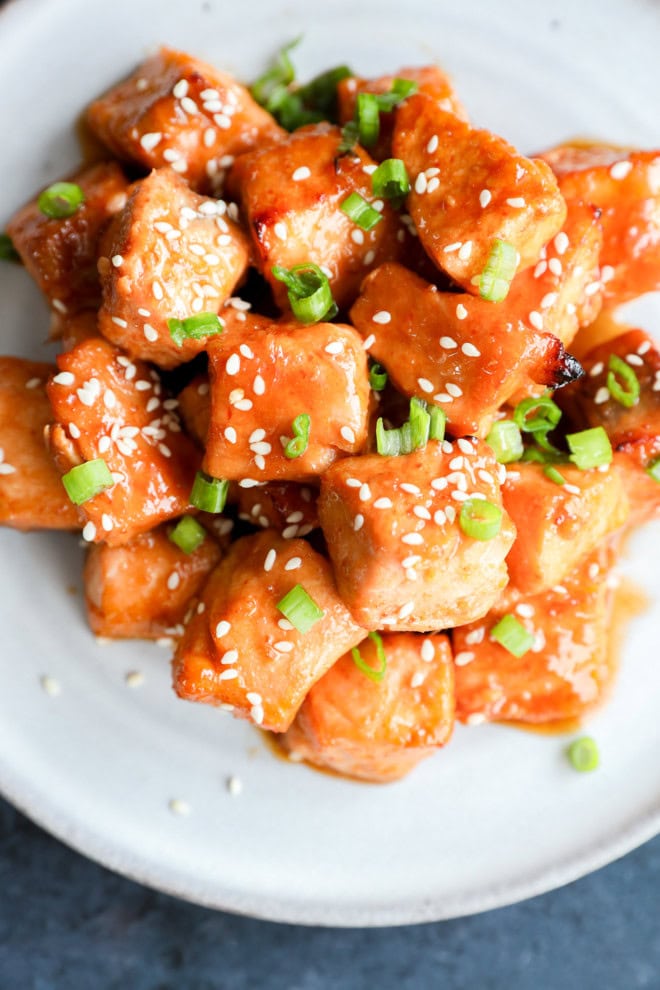 recipe for salmon bites on platter with sesame seeds and green onion on top