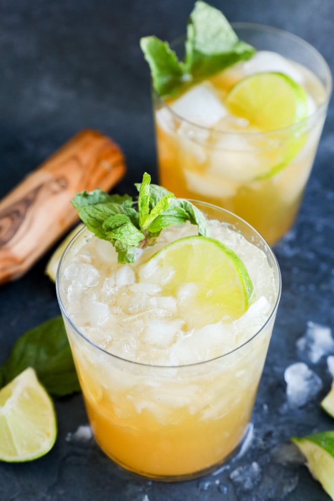 passion fruit and lime mocktail in glasses with muddler and lime