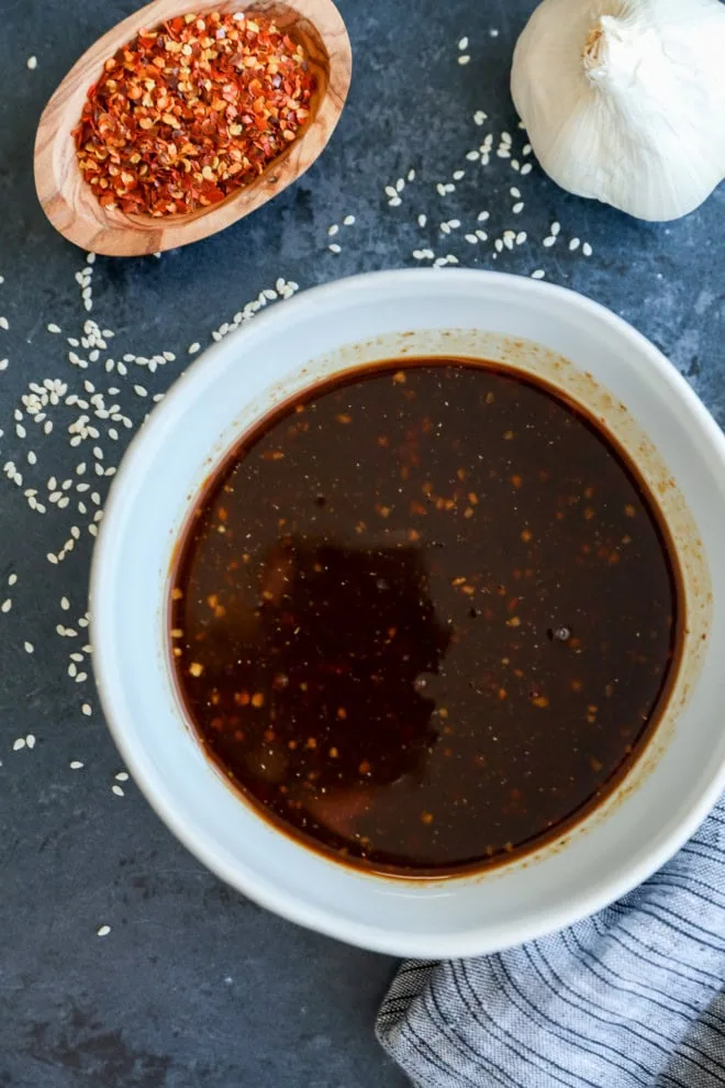 asian pork belly marinade in a bowl with red pepper flakes and garlic