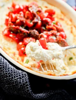 gooey cheese pull with spoon of baked goat cheese appetizer dip