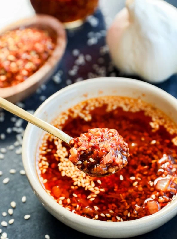 spooning out chili garlic oil recipe from a bowl