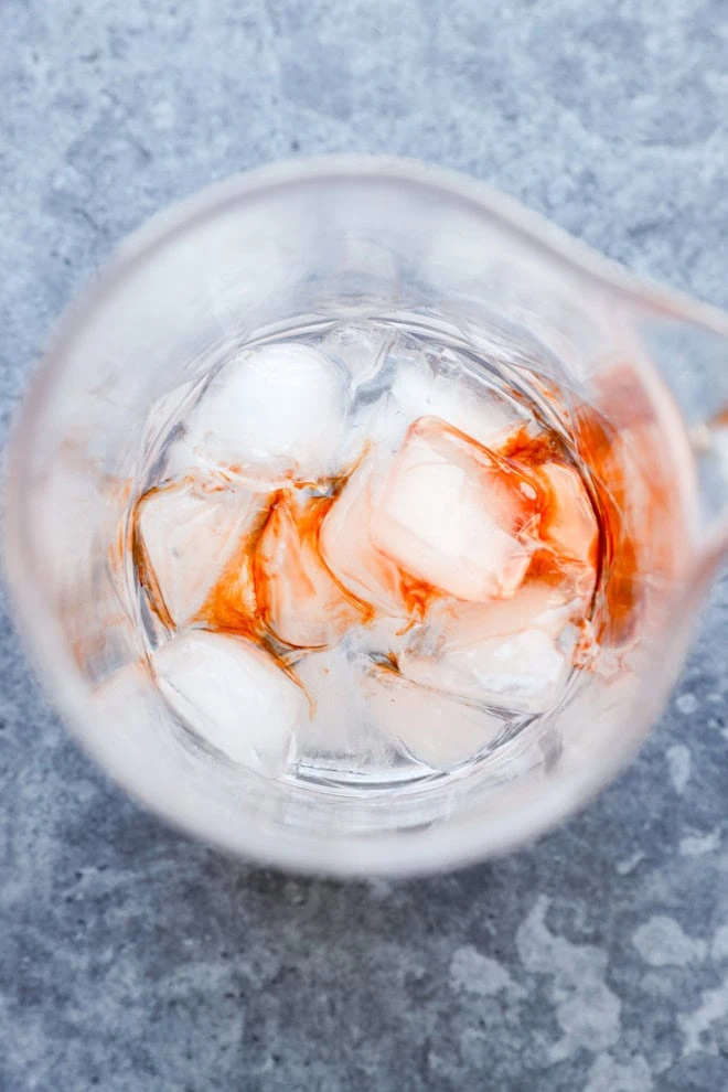 bitters added to mixing glass with ice