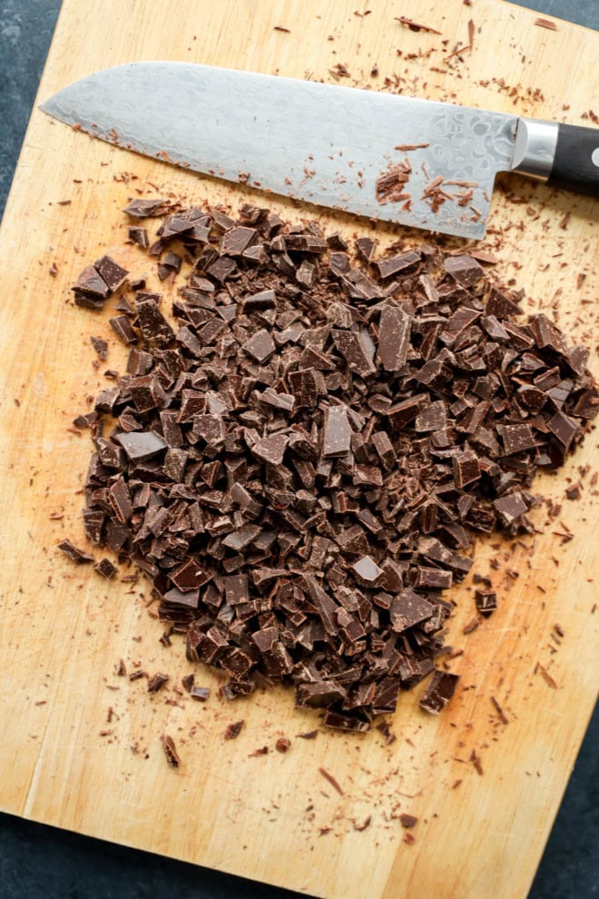 chopped chocolate on cutting board with a knife