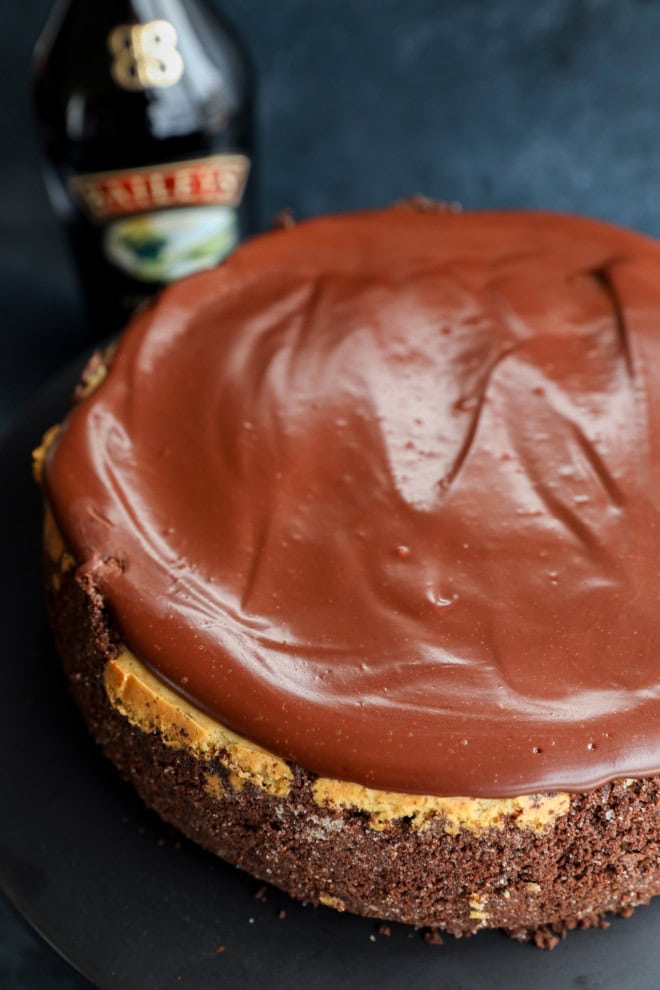 Irish cream dessert on cake plate with bottle in the background