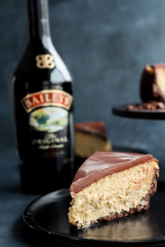 slice of irish cream dessert on black plate with bottle in the background