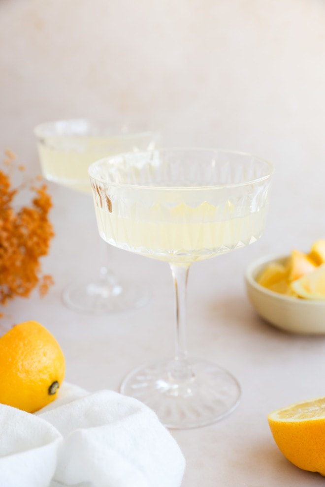 lemony cocktails in coupe glasses with flowers