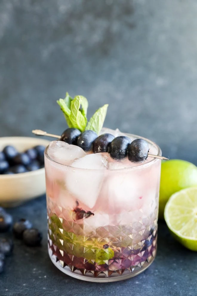 one cocktail with fresh berry drink made with mint and lime