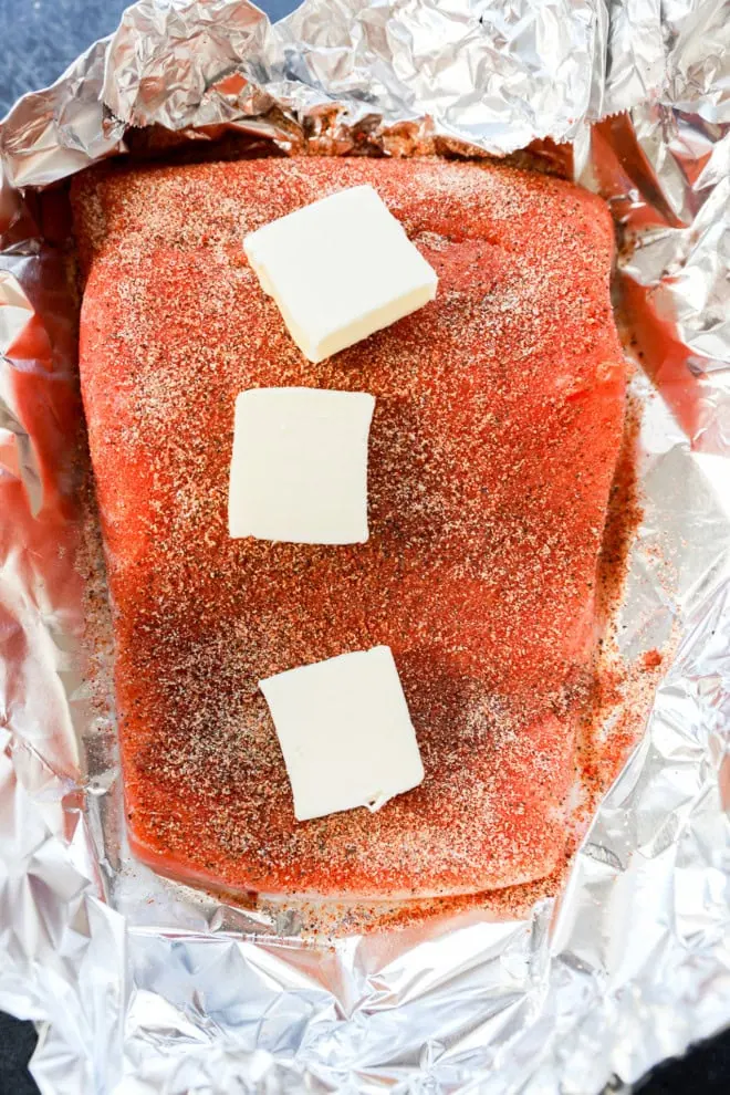 salmon on foil with rub and butter before baking