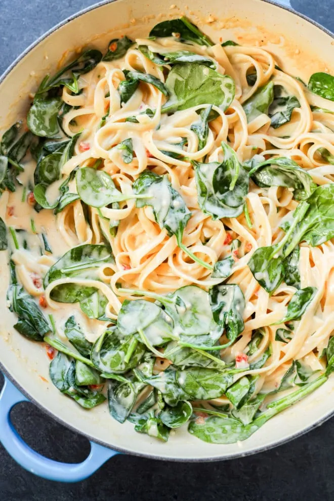 creamy lemon sauce with fettuccine and spinach in a skillet