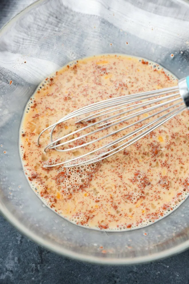 cinnamon custard mixture in a bowl with a whisk